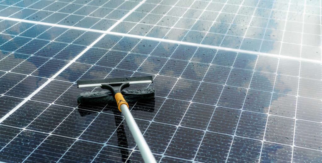Cleaning solar panel with microfiber mop on wet roof. Solar pane